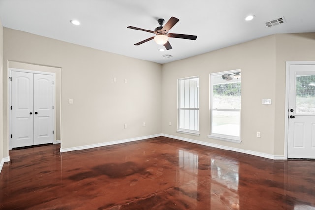 empty room with a wealth of natural light, ceiling fan, and dark hardwood / wood-style floors