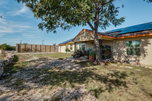 exterior space featuring solar panels and a yard