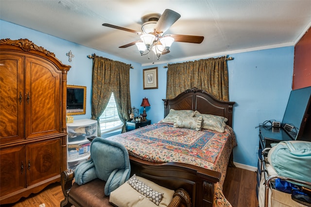 bedroom with crown molding, ceiling fan, and dark hardwood / wood-style floors