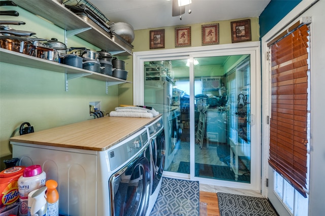 laundry area featuring washing machine and clothes dryer, wood-type flooring, and ceiling fan