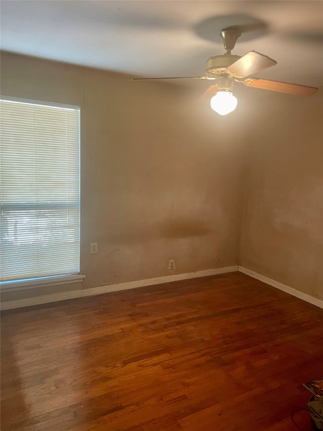 empty room with dark wood-type flooring and ceiling fan