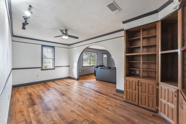 unfurnished room featuring ornamental molding, wood-type flooring, a textured ceiling, and ceiling fan