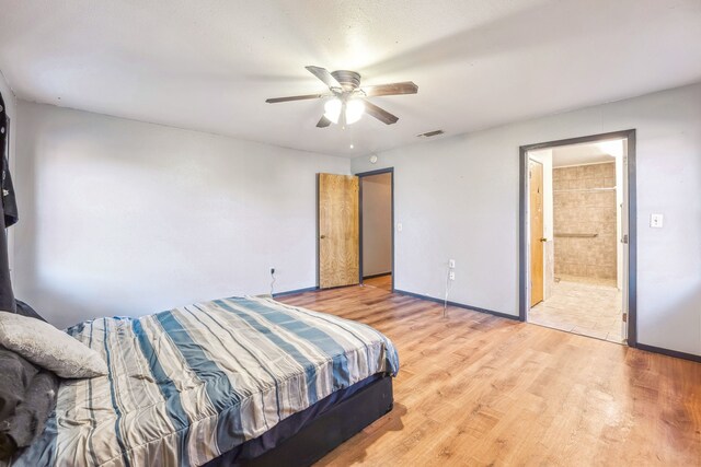 bedroom featuring connected bathroom, light hardwood / wood-style floors, and ceiling fan