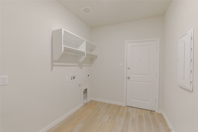 laundry room featuring electric panel, hookup for a washing machine, hookup for a gas dryer, light hardwood / wood-style floors, and electric dryer hookup