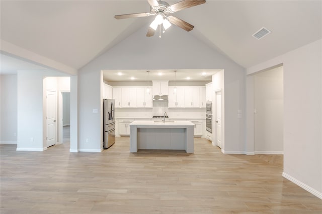 kitchen featuring a center island with sink, sink, appliances with stainless steel finishes, hanging light fixtures, and white cabinets