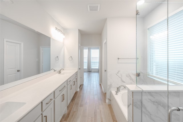 bathroom featuring vanity, hardwood / wood-style flooring, and separate shower and tub