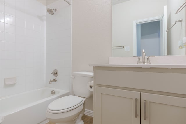 full bathroom with vanity, tiled shower / bath combo, and toilet