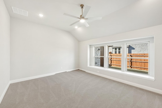 carpeted empty room with ceiling fan and vaulted ceiling