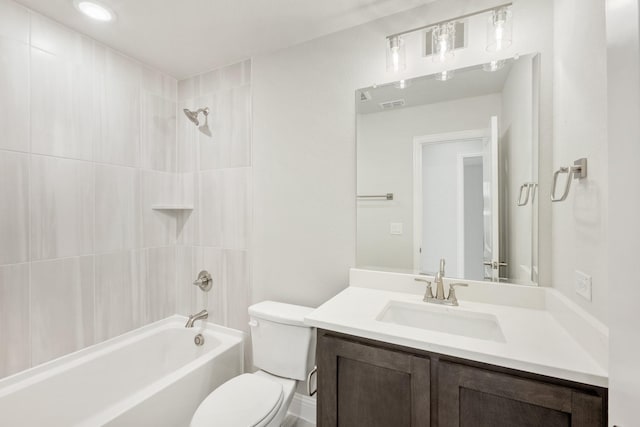 full bathroom with tiled shower / bath, vanity, and toilet