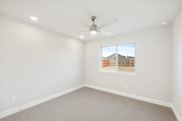 carpeted spare room featuring ceiling fan