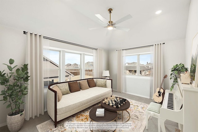 carpeted living room with ceiling fan and vaulted ceiling