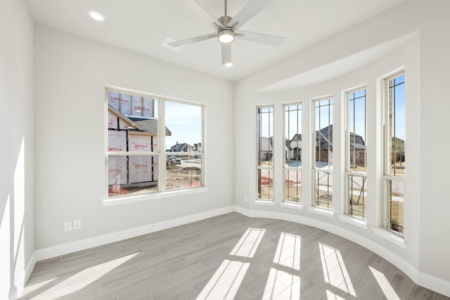 unfurnished sunroom with ceiling fan and plenty of natural light