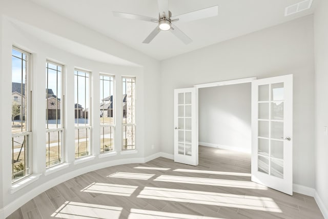 unfurnished sunroom with ceiling fan and french doors