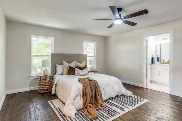 bedroom featuring multiple windows, ceiling fan, dark hardwood / wood-style flooring, and connected bathroom