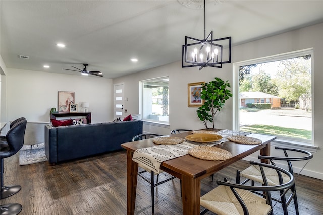 dining space featuring dark wood-type flooring and ceiling fan with notable chandelier