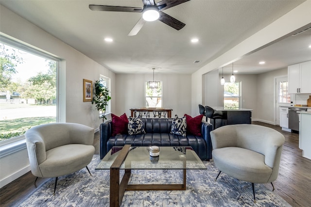 living room with ceiling fan and dark wood-type flooring