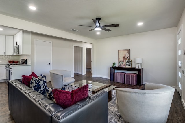 living room featuring ceiling fan and dark wood-type flooring