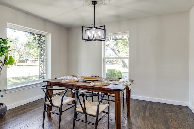 dining space featuring an inviting chandelier, plenty of natural light, and dark hardwood / wood-style floors