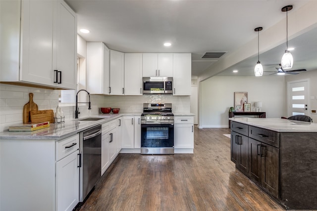 kitchen with sink, white cabinetry, ceiling fan, pendant lighting, and appliances with stainless steel finishes