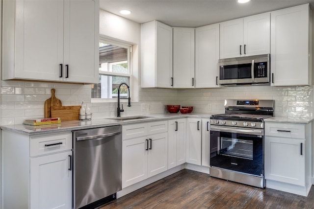 kitchen with stainless steel appliances, white cabinets, sink, and dark hardwood / wood-style floors