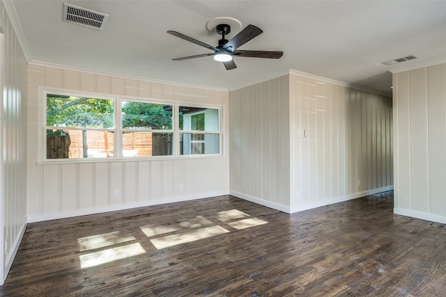 empty room with ornamental molding, ceiling fan, and dark wood-type flooring