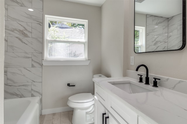 full bathroom featuring toilet, vanity, tiled shower / bath combo, and hardwood / wood-style flooring