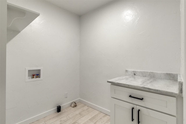 laundry area with cabinets, light hardwood / wood-style flooring, and washer hookup