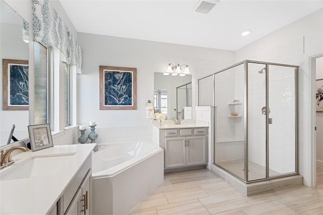 bathroom featuring tile patterned floors, vanity, and shower with separate bathtub