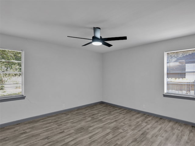 spare room featuring ceiling fan, a healthy amount of sunlight, and light hardwood / wood-style flooring