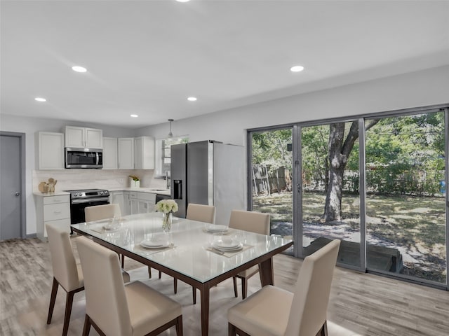 dining space featuring light wood-type flooring and sink