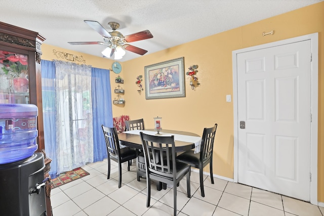 tiled dining space featuring a textured ceiling and ceiling fan