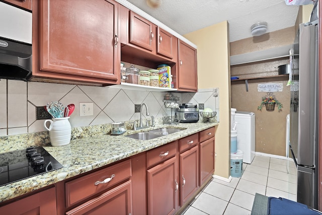 kitchen featuring light tile patterned flooring, sink, backsplash, independent washer and dryer, and stainless steel fridge