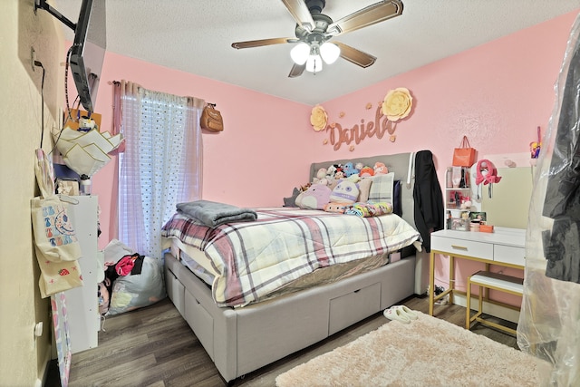 bedroom with ceiling fan, dark hardwood / wood-style floors, and a textured ceiling