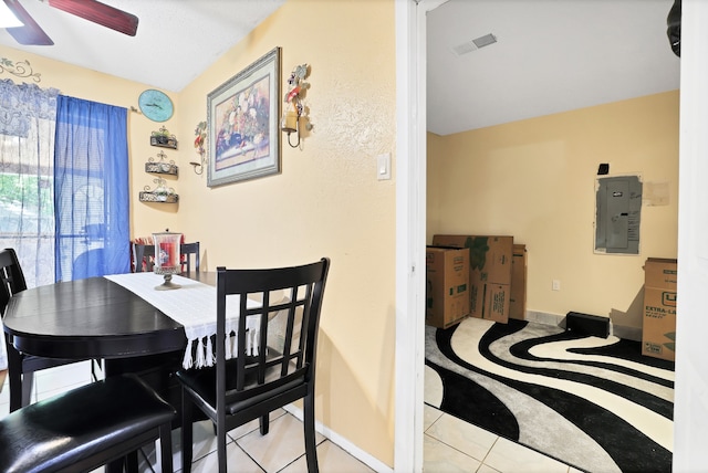 dining room with electric panel, light tile patterned flooring, and ceiling fan