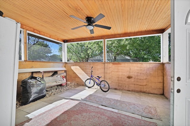 unfurnished sunroom with ceiling fan and wooden ceiling