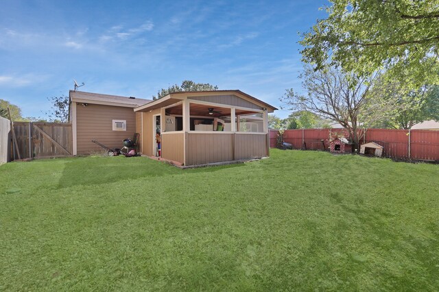 rear view of house with a lawn and ceiling fan