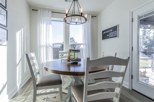 dining space featuring hardwood / wood-style floors and an inviting chandelier