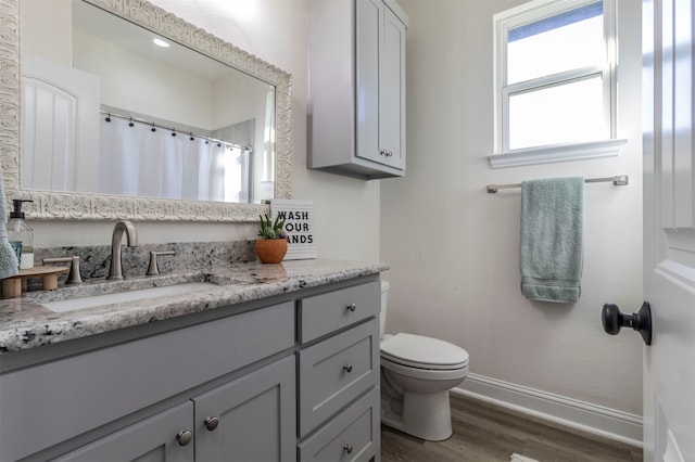 bathroom with hardwood / wood-style flooring, vanity, and toilet