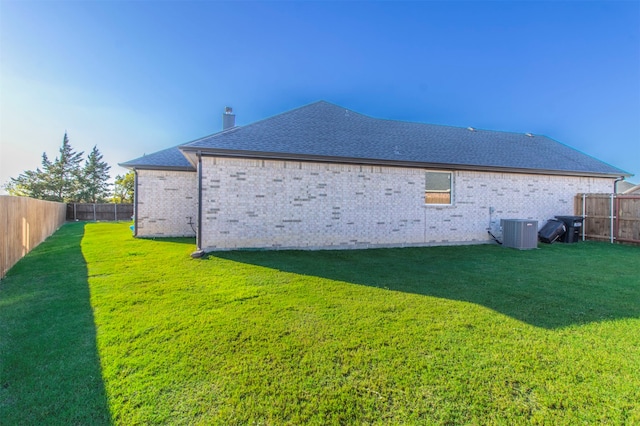 back of house featuring central AC and a lawn