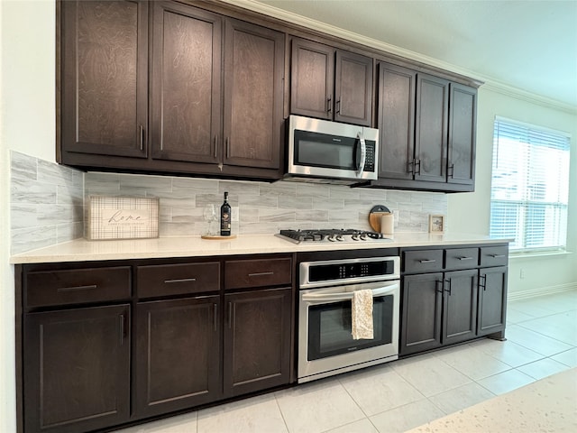 kitchen featuring appliances with stainless steel finishes, dark brown cabinets, and crown molding