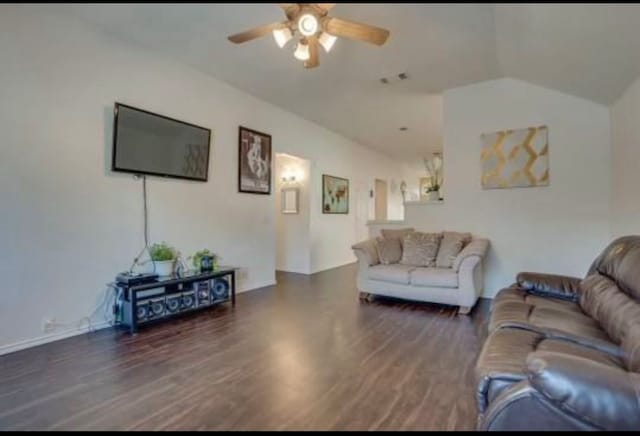 living room with ceiling fan, dark hardwood / wood-style floors, and vaulted ceiling