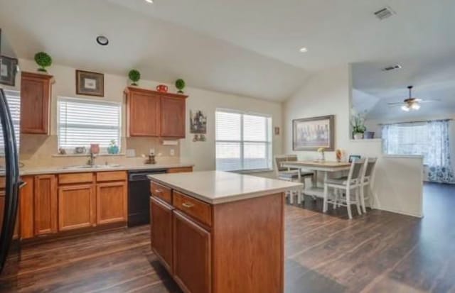 kitchen featuring a wealth of natural light, vaulted ceiling, dishwasher, and a center island