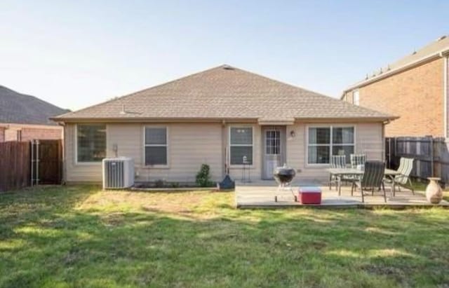 back of property featuring central AC unit and a lawn