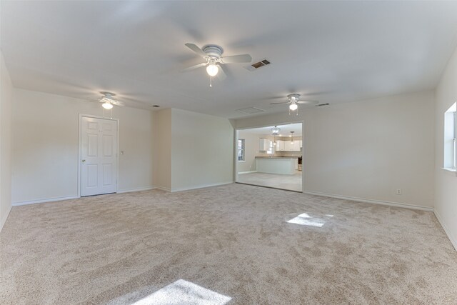 carpeted spare room with ceiling fan