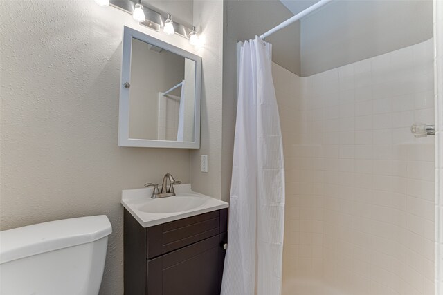 bathroom with a shower with curtain, vanity, and toilet