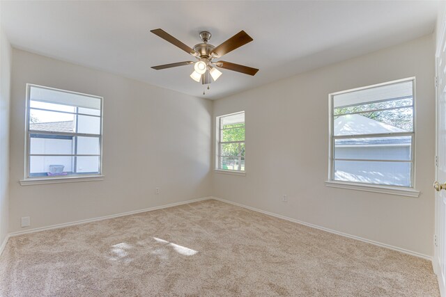 carpeted empty room featuring ceiling fan and a healthy amount of sunlight