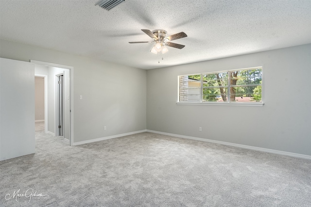 carpeted spare room featuring a textured ceiling and ceiling fan