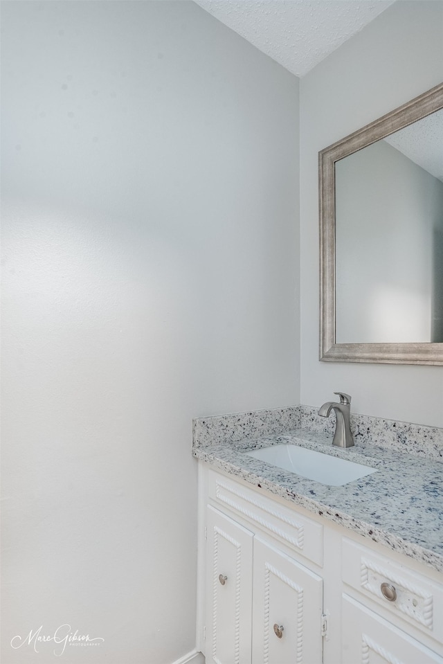 bathroom with vanity and a textured ceiling