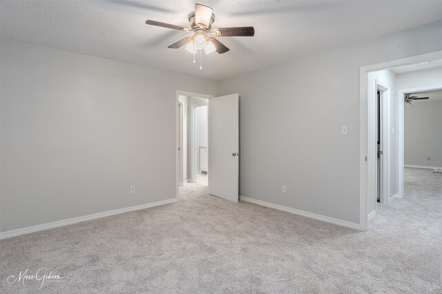 empty room with a textured ceiling, light carpet, and ceiling fan