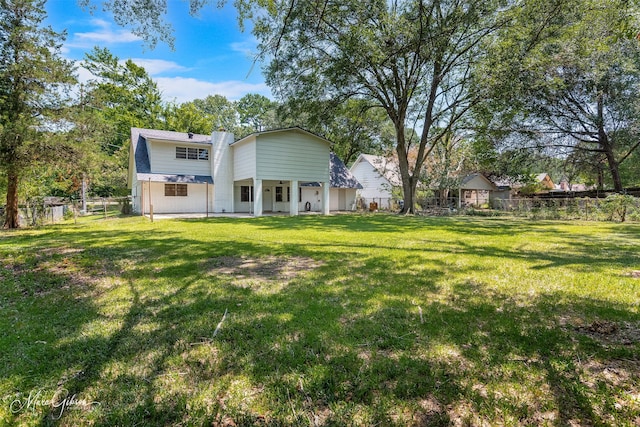 rear view of property with a lawn